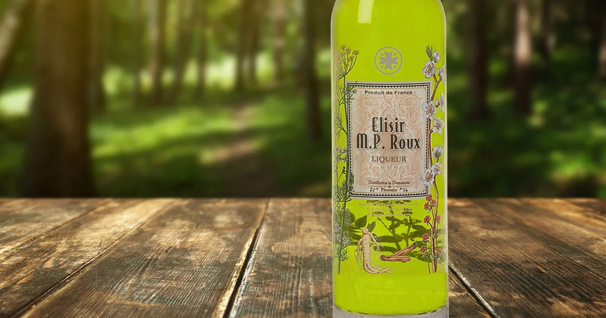 Bouteille d’Elisir M.P. Roux, liqueur française aux plantes de Provence, présentée en pleine forêt.
